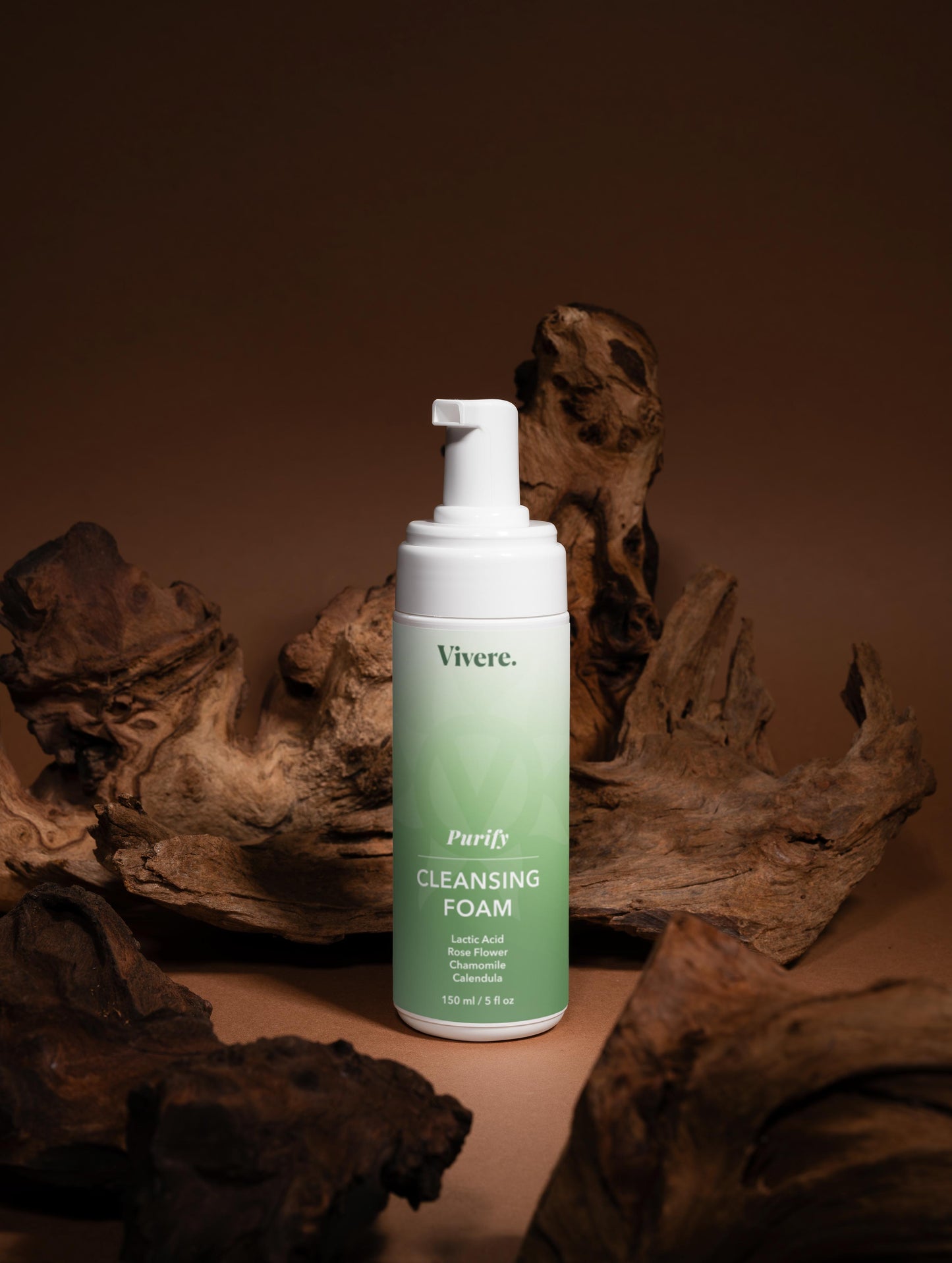 Vivere Purify Cleansing Foam bottle on a brown background with natural elements