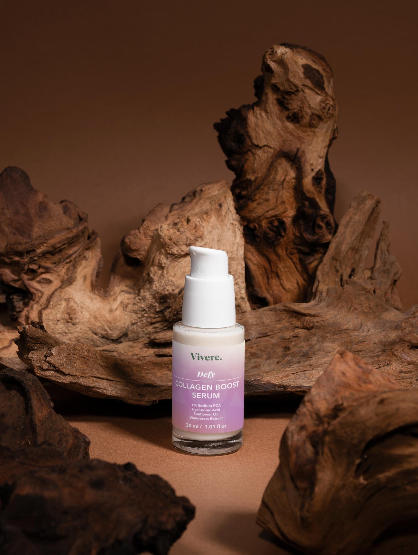 Vivere Collagen Boost Serum bottle on a brown background with natural wood elements